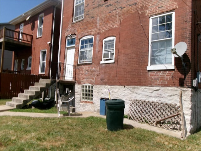 back of property featuring cooling unit, a lawn, and a balcony