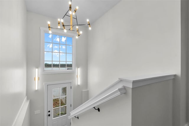 stairs featuring a chandelier