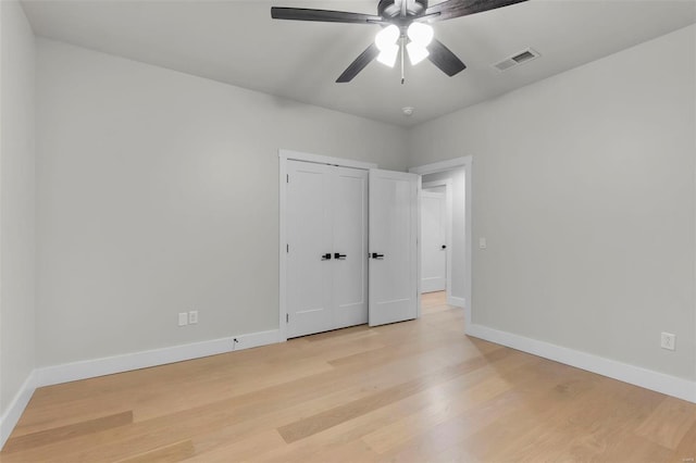 unfurnished bedroom featuring a closet, light hardwood / wood-style floors, and ceiling fan