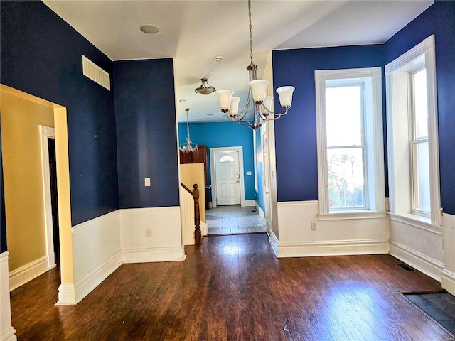 interior space featuring a notable chandelier, plenty of natural light, and dark hardwood / wood-style floors