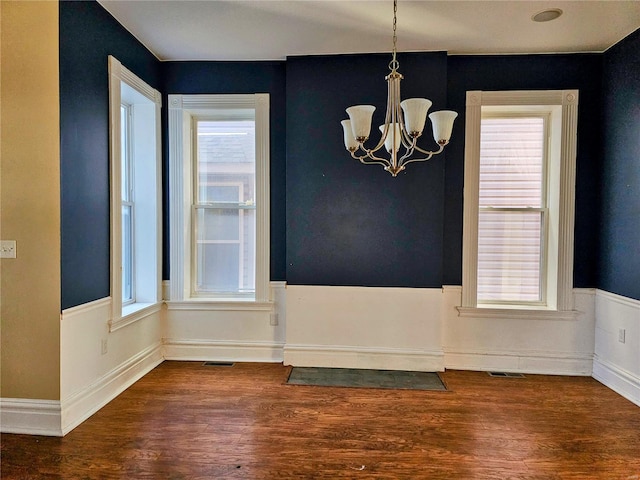 unfurnished dining area featuring dark hardwood / wood-style floors and a wealth of natural light