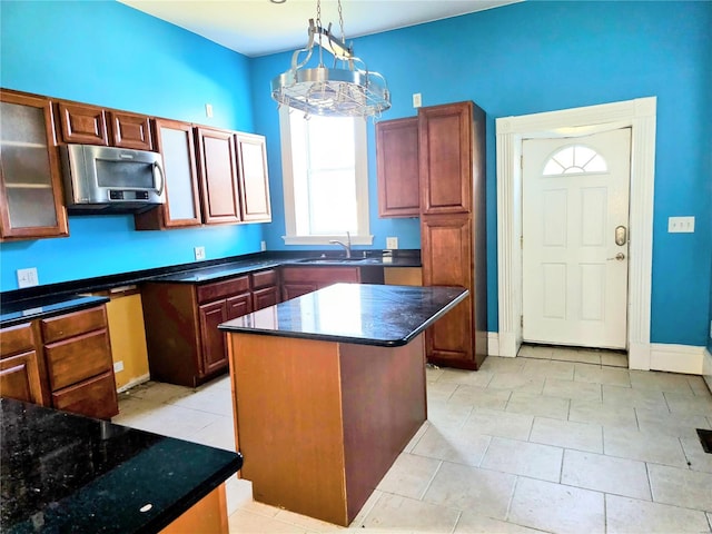 kitchen featuring light tile patterned floors, a notable chandelier, a center island, and hanging light fixtures