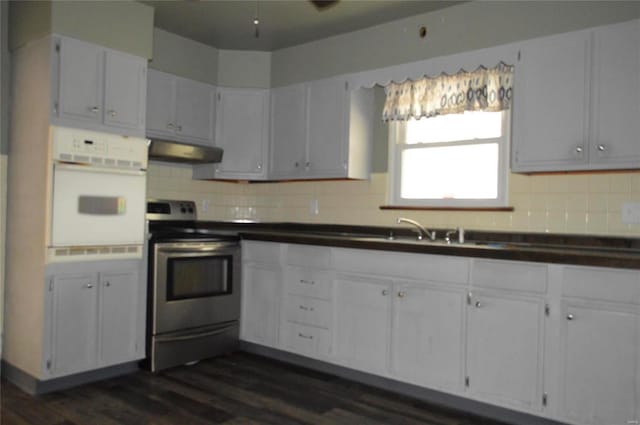 kitchen featuring white cabinets, oven, exhaust hood, and stainless steel range with electric stovetop