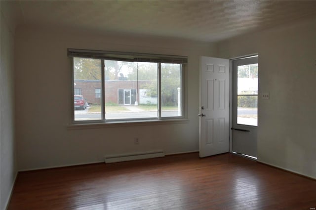 spare room with a textured ceiling, dark hardwood / wood-style floors, and baseboard heating