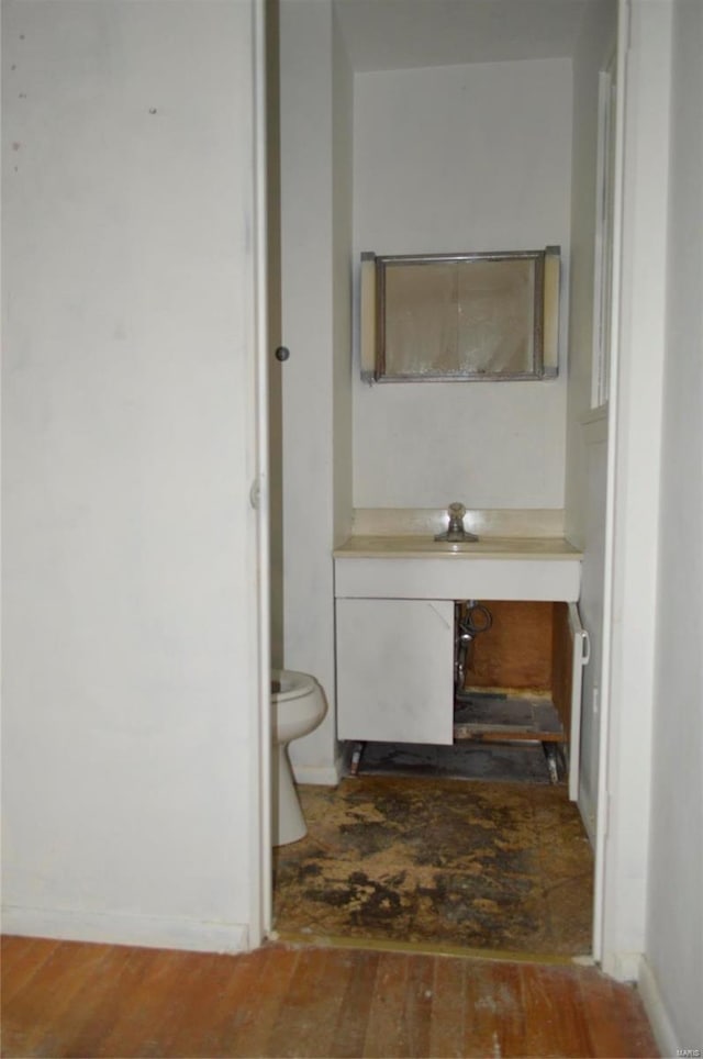 bathroom featuring toilet, vanity, and hardwood / wood-style flooring