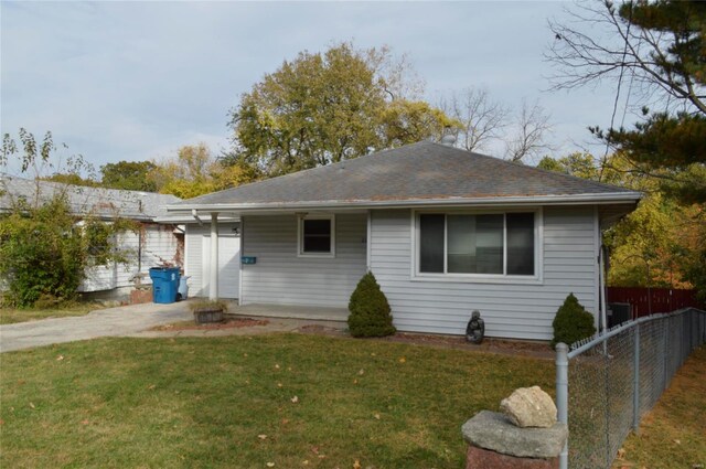 rear view of house featuring a yard and a garage