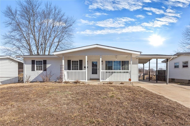 view of front of home featuring a carport, a front yard, and covered porch