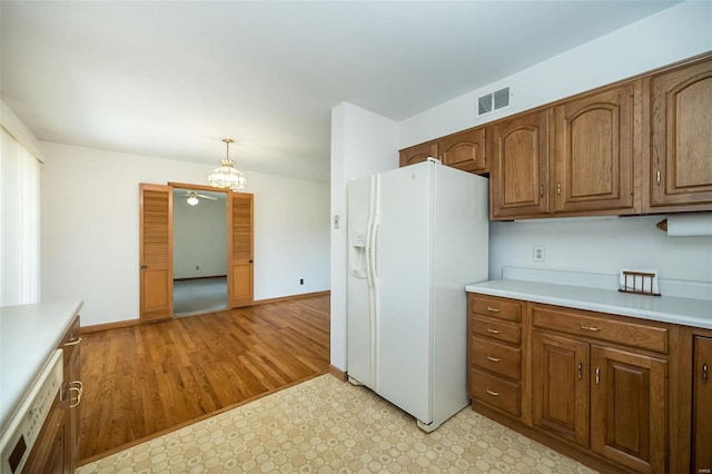 kitchen with visible vents, pendant lighting, white appliances, light countertops, and baseboards