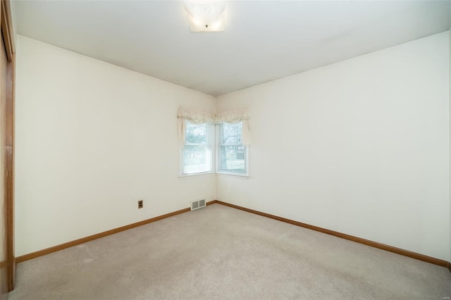 spare room with baseboards, visible vents, and carpet floors