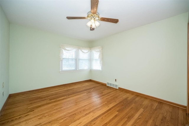 unfurnished room with a ceiling fan, light wood-style flooring, baseboards, and visible vents