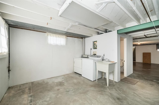 basement featuring stairway, a sink, and separate washer and dryer