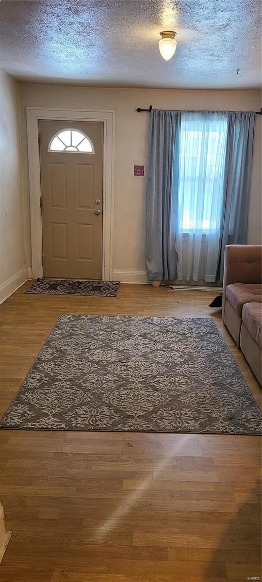 entryway with wood-type flooring and a textured ceiling