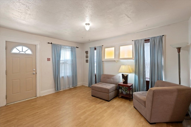 foyer entrance with light hardwood / wood-style floors and a textured ceiling