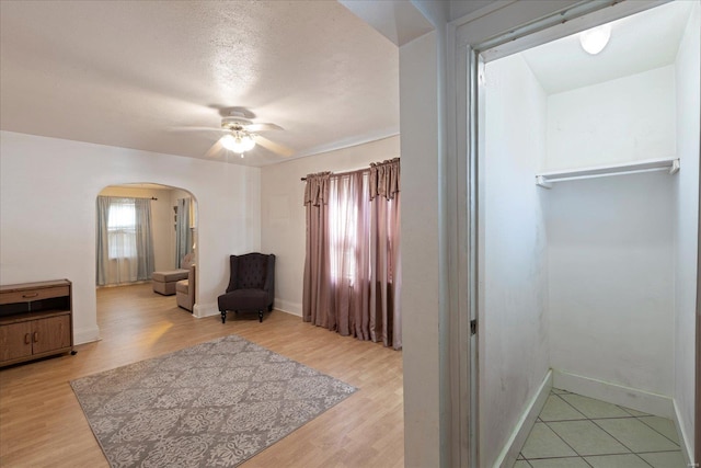 sitting room featuring a textured ceiling, ceiling fan, and light hardwood / wood-style flooring