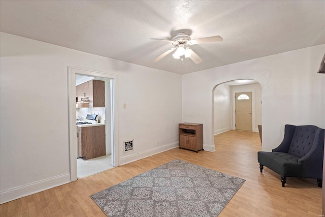 sitting room with a textured ceiling, ceiling fan, and light wood-type flooring