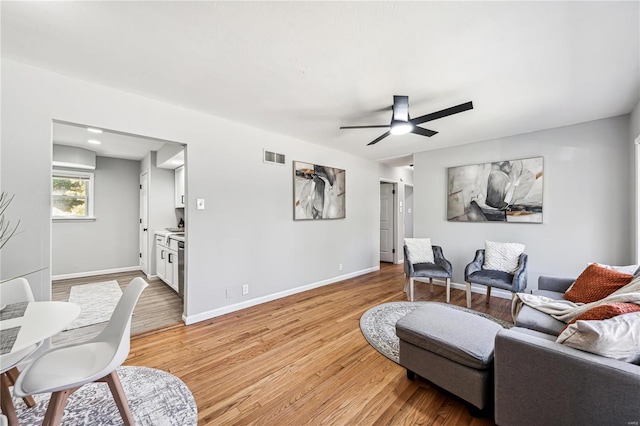 living room featuring light wood-type flooring and ceiling fan