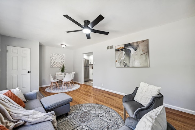 living room featuring hardwood / wood-style flooring and ceiling fan