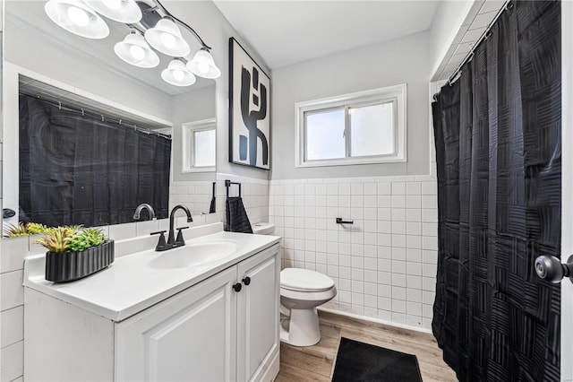 bathroom with wood-type flooring, toilet, tile walls, a shower with curtain, and vanity