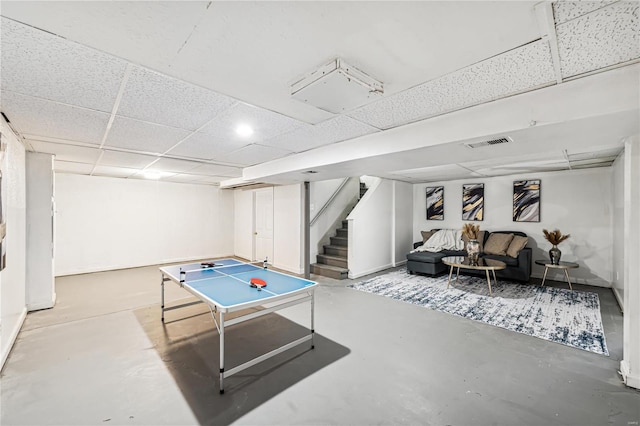 playroom with concrete flooring and a paneled ceiling