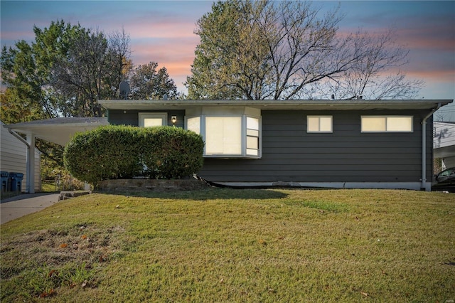 view of front of house with a carport and a lawn