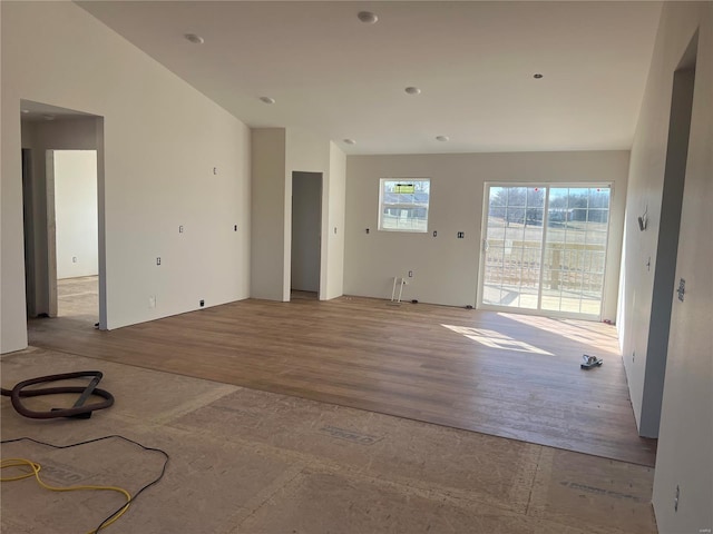 unfurnished living room featuring lofted ceiling and light hardwood / wood-style flooring