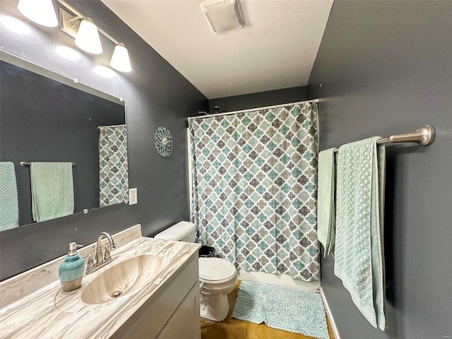 bathroom featuring toilet, a textured ceiling, and vanity