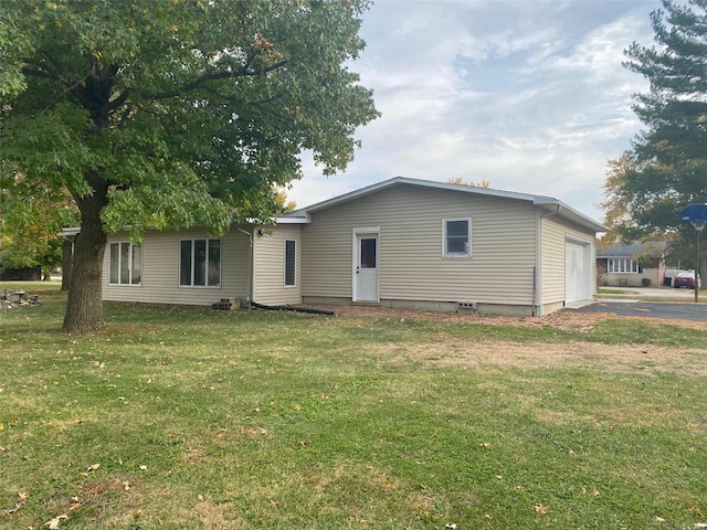 rear view of house with a garage and a lawn