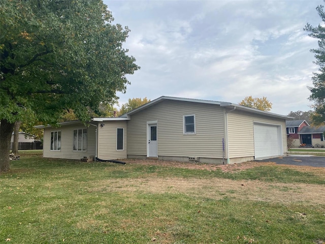 back of property featuring a yard and a garage