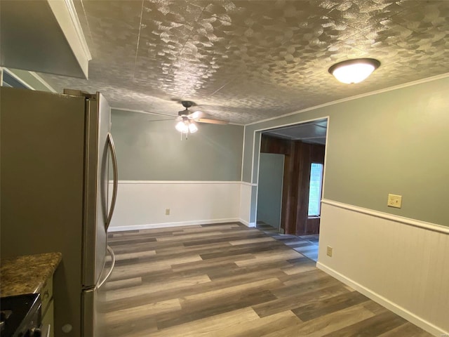 kitchen featuring ceiling fan, ornamental molding, dark hardwood / wood-style floors, and stainless steel fridge