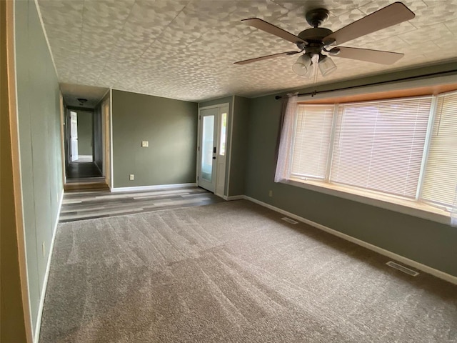 carpeted spare room with ceiling fan and a textured ceiling