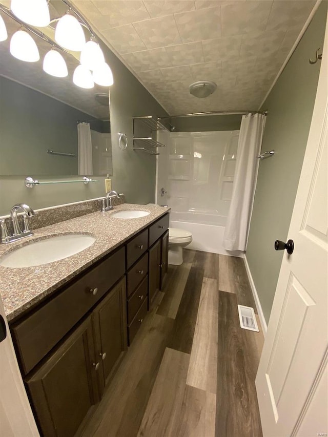 full bathroom featuring vanity, toilet, shower / bath combo with shower curtain, and hardwood / wood-style floors