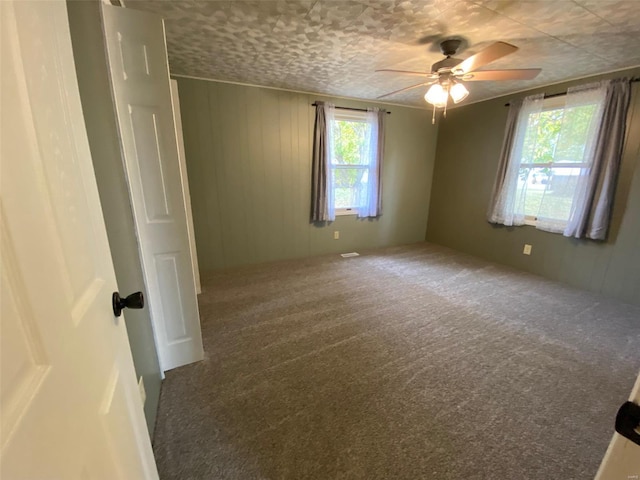 carpeted spare room featuring ceiling fan