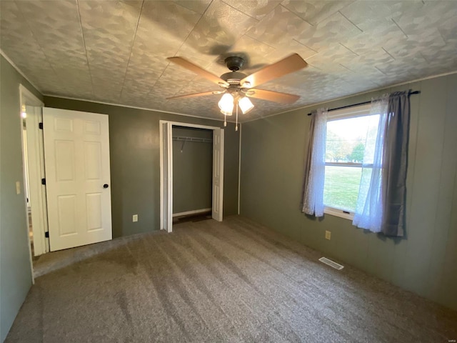 unfurnished bedroom featuring carpet flooring, a closet, and ceiling fan