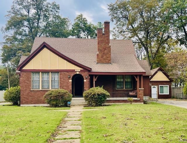 tudor-style house featuring a front lawn