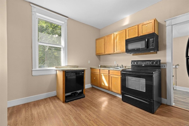 kitchen with light hardwood / wood-style floors and black appliances