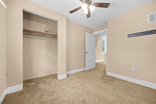 unfurnished bedroom with a closet, carpet floors, and ceiling fan