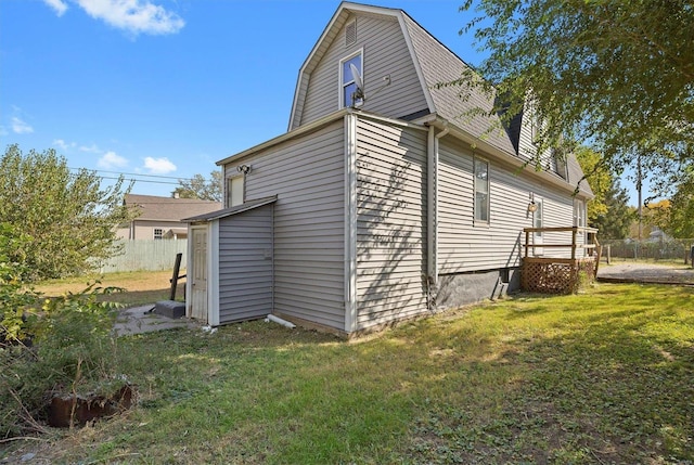 view of side of property with a yard and a deck