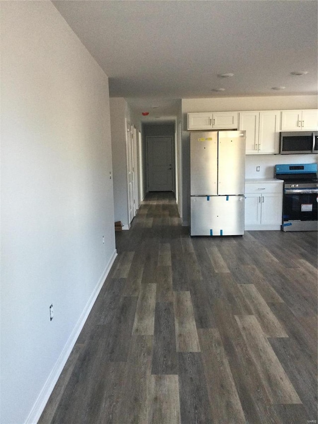 kitchen with stainless steel appliances, dark hardwood / wood-style floors, and white cabinets