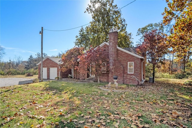 view of side of home featuring central AC and a yard