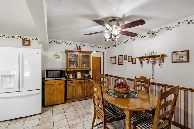 tiled dining area with ceiling fan