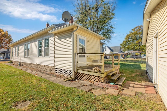 view of property exterior with a yard and a deck