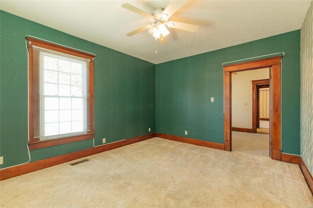 empty room featuring light carpet and ceiling fan