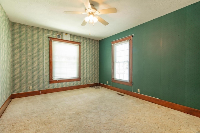 carpeted empty room featuring a textured ceiling and ceiling fan