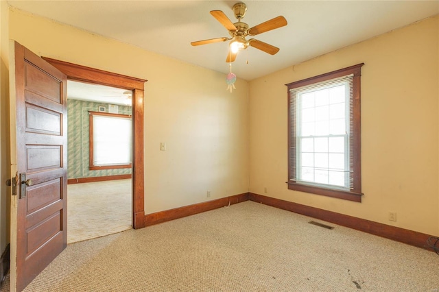 carpeted empty room featuring ceiling fan