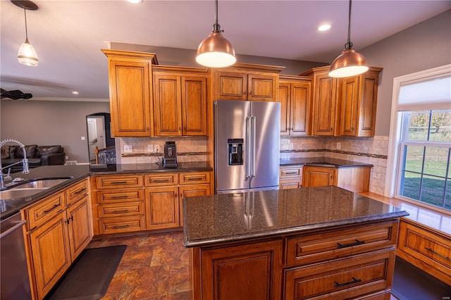 kitchen with decorative light fixtures, stainless steel appliances, sink, and backsplash