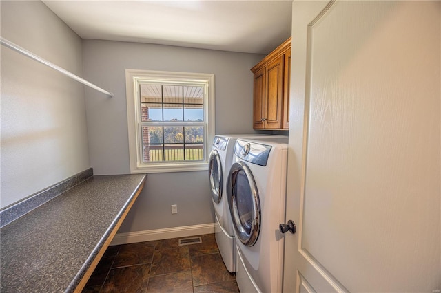 laundry room with washing machine and clothes dryer and cabinets