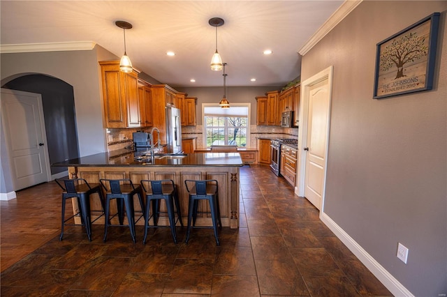 kitchen featuring kitchen peninsula, backsplash, appliances with stainless steel finishes, crown molding, and decorative light fixtures