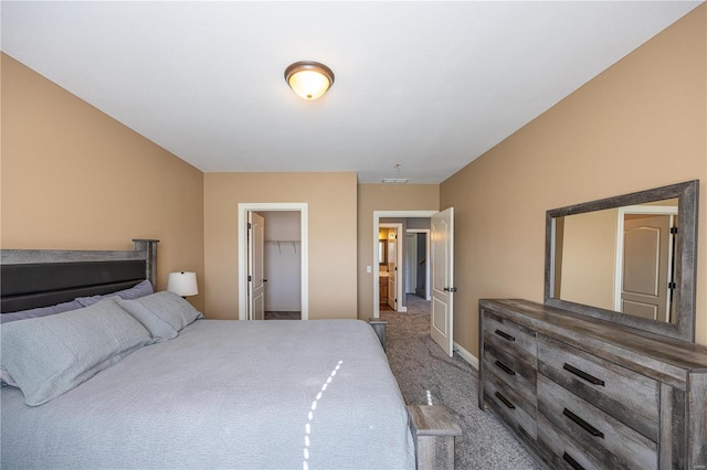 carpeted bedroom featuring a spacious closet and a closet