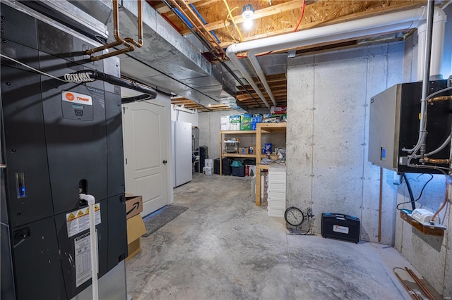 basement with white fridge and heating unit