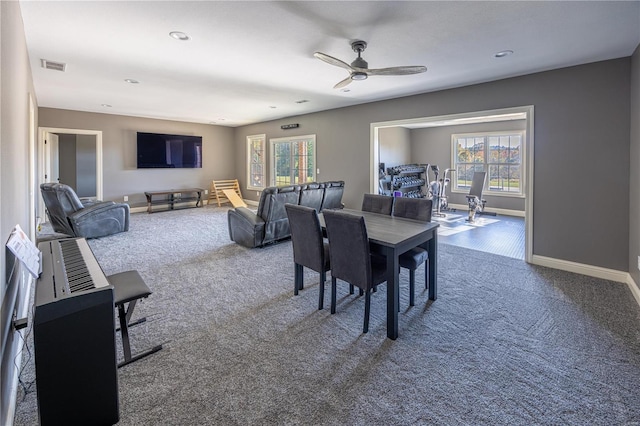 carpeted dining area with ceiling fan